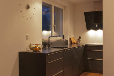 Moderne Küche mit Unterbauwaschbecken, braunem Holzboden und braunem Boden in Sonstige