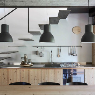 Esempio di una piccola cucina industriale con lavello integrato, ante lisce, ante beige, top in acciaio inossidabile, elettrodomestici da incasso, nessuna isola e top grigio