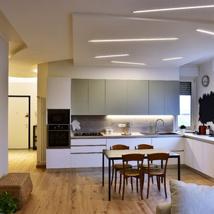 Esempio di una cucina contemporanea con ante lisce, ante bianche, lavello a doppia vasca, paraspruzzi grigio, elettrodomestici neri, pavimento in legno massello medio, nessuna isola e pavimento marrone