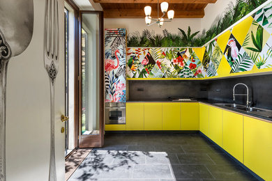 Источник вдохновения для домашнего уюта: угловая кухня в современном стиле с двойной мойкой, плоскими фасадами, желтыми фасадами, черным фартуком и обоями на стенах