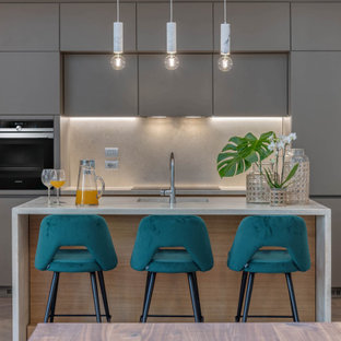 Ispirazione per una grande cucina contemporanea con ante lisce, ante grigie, top in pietra calcarea, paraspruzzi in pietra calcarea, elettrodomestici in acciaio inossidabile, parquet chiaro, lavello a vasca singola, paraspruzzi grigio e top grigio