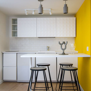 Ispirazione per una cucina lineare design di medie dimensioni con ante bianche, top bianco, ante lisce, paraspruzzi bianco, penisola, pavimento marrone e pavimento in legno massello medio