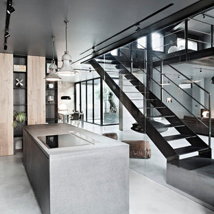Design ideas for a mid-sized contemporary kitchen in Milan with flat-panel cabinets, light wood cabinets, concrete benchtops, concrete floors and with island.