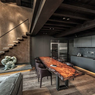 Immagine di una cucina minimal con lavello sottopiano, ante lisce, ante grigie, elettrodomestici in acciaio inossidabile, parquet scuro, nessuna isola, pavimento marrone e top grigio