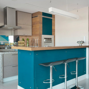 Foto di una cucina design con ante lisce, ante beige, top in granito, paraspruzzi a specchio, elettrodomestici in acciaio inossidabile e pavimento grigio