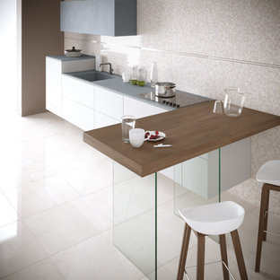 Photo of a l-shaped open plan kitchen in Bologna with black cabinets, porcelain splashback, porcelain floors, with island, multi-coloured splashback and pink floor.