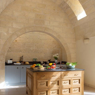 Esempio di una cucina parallela mediterranea con ante in stile shaker, ante in legno chiaro, isola, pavimento grigio e top grigio