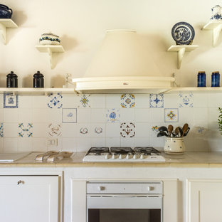 Esempio di una cucina a L mediterranea con lavello da incasso, ante con riquadro incassato, ante bianche, paraspruzzi multicolore, elettrodomestici bianchi e top beige