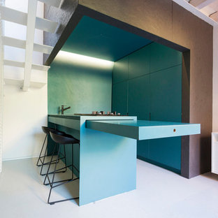 Immagine di una piccola cucina contemporanea con ante lisce, ante blu, elettrodomestici da incasso, penisola, top blu, lavello a vasca singola, top in legno e pavimento grigio