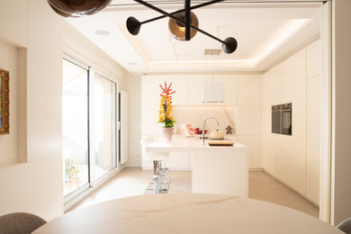 Esempio di una cucina minimal con lavello integrato, ante bianche, top in superficie solida, paraspruzzi in marmo, elettrodomestici neri, pavimento con piastrelle in ceramica, pavimento beige e top bianco