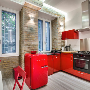 Foto di una cucina minimal di medie dimensioni con ante lisce, ante rosse, paraspruzzi a effetto metallico, paraspruzzi con piastrelle di metallo, elettrodomestici neri e pavimento in legno massello medio