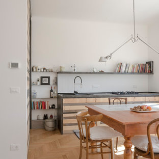Foto di una cucina contemporanea con lavello sottopiano, ante lisce, ante in legno chiaro, paraspruzzi bianco, pavimento in legno massello medio, nessuna isola, pavimento marrone e top grigio