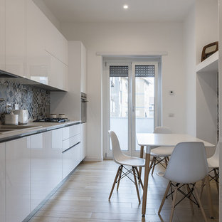 Immagine di una cucina lineare contemporanea chiusa con lavello a doppia vasca, ante lisce, ante bianche, paraspruzzi multicolore, elettrodomestici in acciaio inossidabile, parquet chiaro, nessuna isola, pavimento beige e top bianco