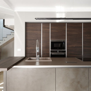 Idee per una cucina contemporanea di medie dimensioni con lavello da incasso, ante lisce, ante in legno scuro, pavimento beige e top grigio