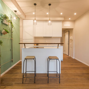 Ispirazione per una cucina contemporanea di medie dimensioni con pavimento marrone, ante bianche, paraspruzzi bianco, ante lisce e pavimento in legno massello medio
