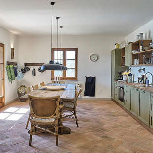 Large country single-wall eat-in kitchen in Florence with raised-panel cabinets, green cabinets, wood benchtops, white splashback, stainless steel appliances, brick floors, no island and red floor.