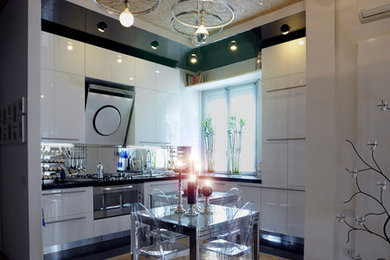 Imagen de cocinas en L contemporánea abierta con armarios con paneles lisos, puertas de armario blancas y electrodomésticos de acero inoxidable