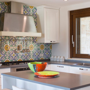 Esempio di una piccola cucina a L design con lavello a doppia vasca, ante lisce, ante bianche, paraspruzzi multicolore, paraspruzzi con piastrelle a mosaico, elettrodomestici in acciaio inossidabile, isola e top grigio