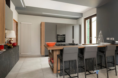 Immagine di una cucina minimalista di medie dimensioni con lavello a doppia vasca, elettrodomestici neri, pavimento in gres porcellanato e pavimento grigio