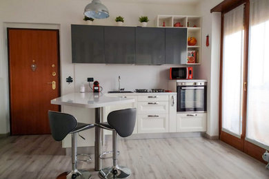 Esempio di una cucina moderna di medie dimensioni con lavello a vasca singola, ante lisce, ante bianche, top in laminato, paraspruzzi bianco, elettrodomestici neri, penisola, pavimento grigio e top bianco