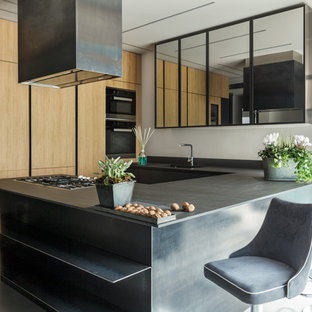 Ispirazione per una cucina ad U industriale di medie dimensioni con ante lisce, ante in legno scuro, penisola e top nero