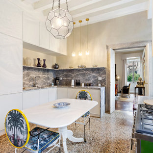 Ispirazione per una cucina mediterranea con lavello sottopiano, ante lisce, ante bianche, paraspruzzi grigio, paraspruzzi in lastra di pietra, nessuna isola, pavimento marrone e top grigio