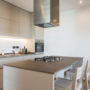 Offene, Einzeilige, Mittelgroße Moderne Küche mit Waschbecken, flächenbündigen Schrankfronten, grauen Schränken, Kalkstein-Arbeitsplatte, Küchenrückwand in Grau, Rückwand aus Stein, Küchengeräten aus Edelstahl, dunklem Holzboden, Kücheninsel, buntem Boden und grauer Arbeitsplatte in Bologna