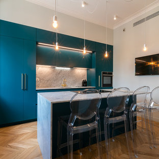 Foto di una cucina contemporanea con ante lisce, ante blu, paraspruzzi bianco, elettrodomestici in acciaio inossidabile e top bianco