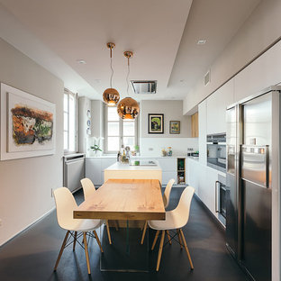 Foto di una cucina contemporanea con ante lisce, ante bianche, paraspruzzi bianco, elettrodomestici in acciaio inossidabile, pavimento nero e top bianco