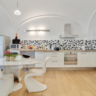 Immagine di una cucina design con ante lisce, ante bianche, paraspruzzi multicolore, elettrodomestici in acciaio inossidabile, parquet chiaro, nessuna isola, pavimento beige, top grigio e soffitto a volta