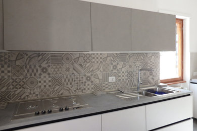 Immagine di una cucina lineare moderna chiusa e di medie dimensioni con lavello a doppia vasca, paraspruzzi in gres porcellanato, pavimento in ardesia, pavimento grigio e top grigio
