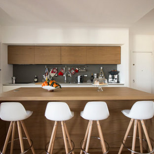 Esempio di un cucina con isola centrale minimal con ante lisce, ante marroni, paraspruzzi grigio e pavimento marrone