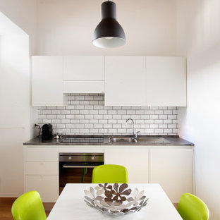 Idee per una piccola cucina minimal con nessuna isola, ante lisce, ante bianche, paraspruzzi bianco, paraspruzzi con piastrelle diamantate, pavimento in legno massello medio e pavimento marrone