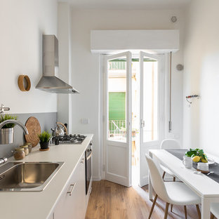 Ispirazione per una piccola cucina scandinava con ante lisce, ante bianche, paraspruzzi grigio, pavimento in legno massello medio, nessuna isola, pavimento marrone, lavello da incasso, paraspruzzi con lastra di vetro e elettrodomestici in acciaio inossidabile