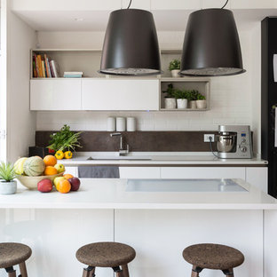 Idee per una cucina minimal con lavello sottopiano, ante lisce, ante bianche, paraspruzzi grigio e top bianco