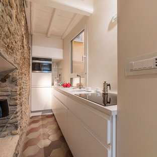 Idee per una piccola cucina mediterranea con lavello sottopiano, ante lisce, ante bianche, nessuna isola, pavimento multicolore e top bianco