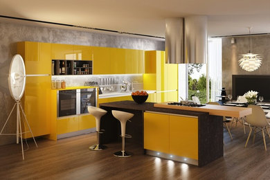 Foto di un cucina con isola centrale minimal con ante lisce, ante gialle e paraspruzzi grigio