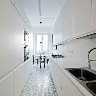Inspiration för mellanstora skandinaviska kök, med släta luckor, vita skåp, vitt stänkskydd, cementgolv, en nedsänkt diskho, integrerade vitvaror och blått golv