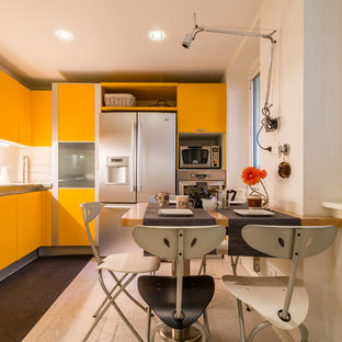 Idee per una cucina design con ante lisce, paraspruzzi bianco, ante gialle, elettrodomestici in acciaio inossidabile e top grigio