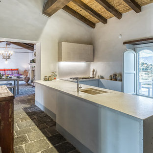 Ispirazione per una cucina ad U mediterranea chiusa con lavello sottopiano, paraspruzzi grigio, penisola, pavimento grigio e top grigio