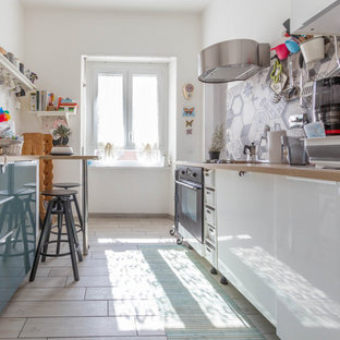 Ispirazione per una cucina parallela boho chic con ante lisce, ante bianche, top in legno, paraspruzzi grigio, elettrodomestici neri, pavimento beige e top beige