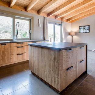 Immagine di una cucina mediterranea con ante in legno scuro, top nero, lavello a vasca singola, ante lisce, elettrodomestici da incasso e pavimento marrone