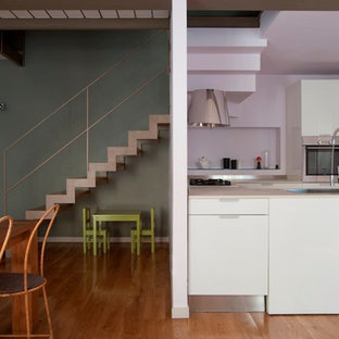 Inspiration for a large contemporary eat-in kitchen in Turin with marble benchtops, stainless steel appliances, medium hardwood floors and pink floor.