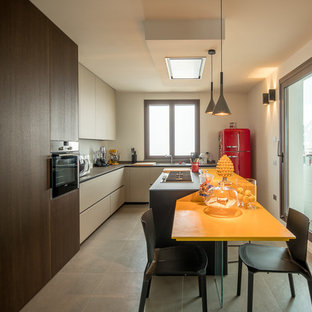 Foto di una grande cucina a L minimal con ante lisce, paraspruzzi bianco, pavimento grigio, lavello sottopiano, ante beige e elettrodomestici colorati
