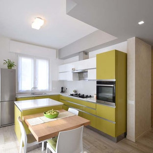Foto di una cucina design con ante lisce, ante verdi, elettrodomestici in acciaio inossidabile, top bianco, lavello a vasca singola e paraspruzzi bianco
