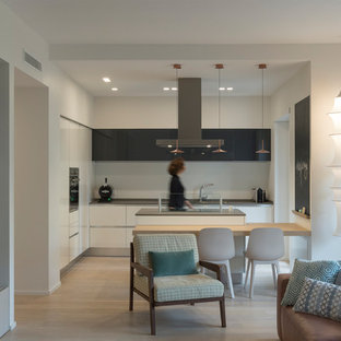 Immagine di una cucina contemporanea di medie dimensioni con lavello a doppia vasca, ante lisce, paraspruzzi bianco, elettrodomestici in acciaio inossidabile, parquet chiaro, top grigio, ante bianche e pavimento beige