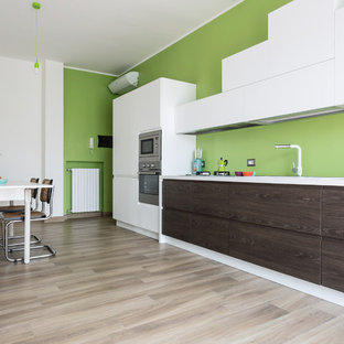 Ispirazione per una grande cucina contemporanea con paraspruzzi verde, elettrodomestici in acciaio inossidabile, parquet chiaro, nessuna isola, top bianco, ante lisce e ante in legno bruno