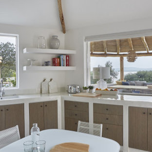 Ispirazione per una cucina stile marino con lavello integrato, ante lisce, ante in legno scuro, nessuna isola e top bianco