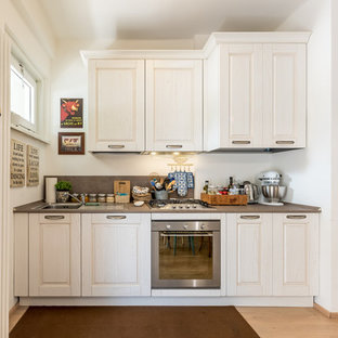 Idee per una cucina lineare shabby-chic style con ante con riquadro incassato, ante bianche, paraspruzzi bianco, elettrodomestici in acciaio inossidabile e top grigio