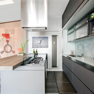 Esempio di una cucina parallela design di medie dimensioni con ante con riquadro incassato, ante grigie, top in acciaio inossidabile, paraspruzzi blu, paraspruzzi con piastrelle in ceramica, elettrodomestici da incasso, parquet scuro, lavello da incasso, penisola e pavimento nero